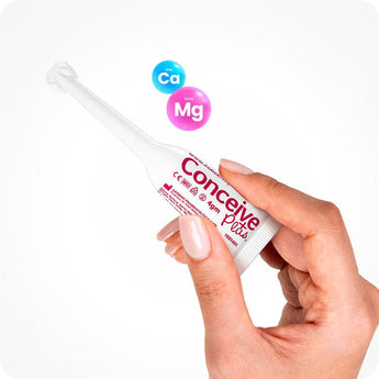 For Conceive Plus Fertility Lubricant Duo Bundle (75ml and 8 Applicators), showing a hand holding a single 4g pre-filled fertility lubricant applicators with pink branding, alongside calcium (Ca) and magnesium (Mg) ion icons, emphasizing product’s mineral formulation and ease of intra-vaginal use.
